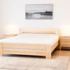 a bed with a painting on the wall
